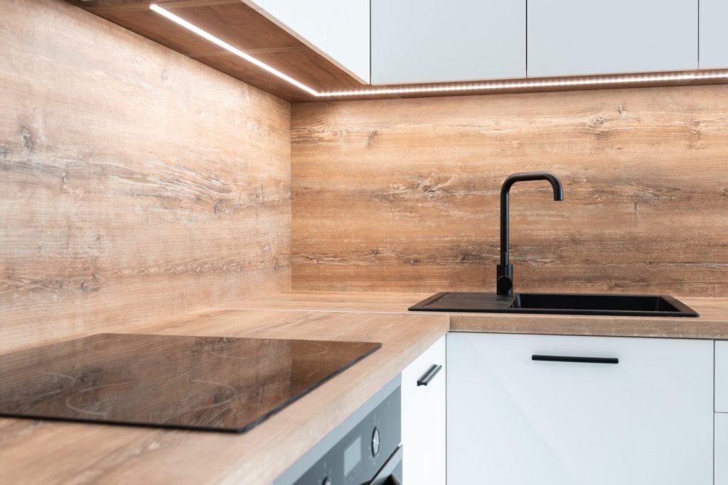 A Kitchen With A Wooden Countertop And Back splash