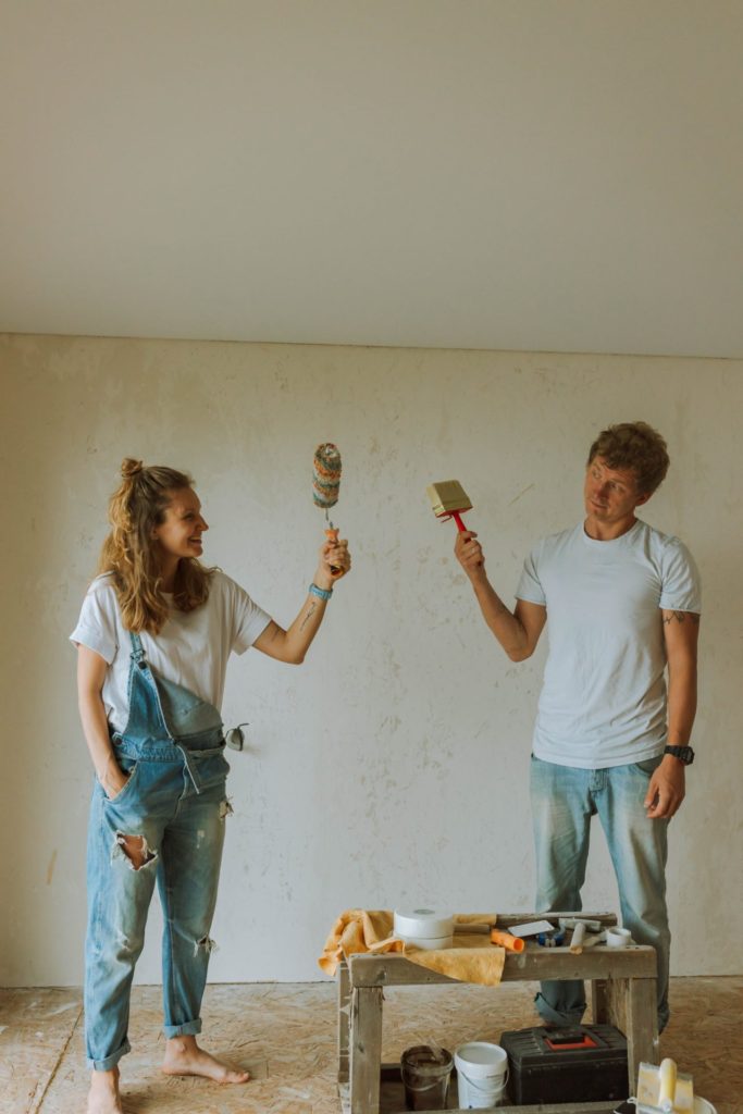 Young Couple Painting An Empty Room