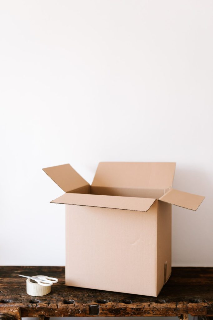 An empty cardboard box with scissors and tape