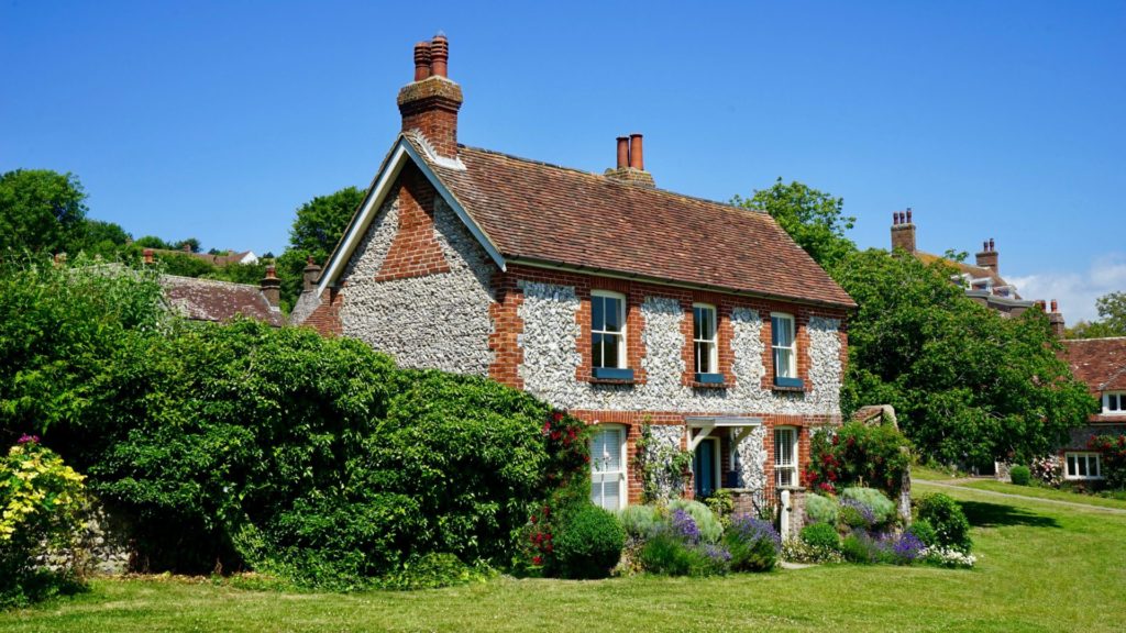 Photo of an ancestral home with a green garden
